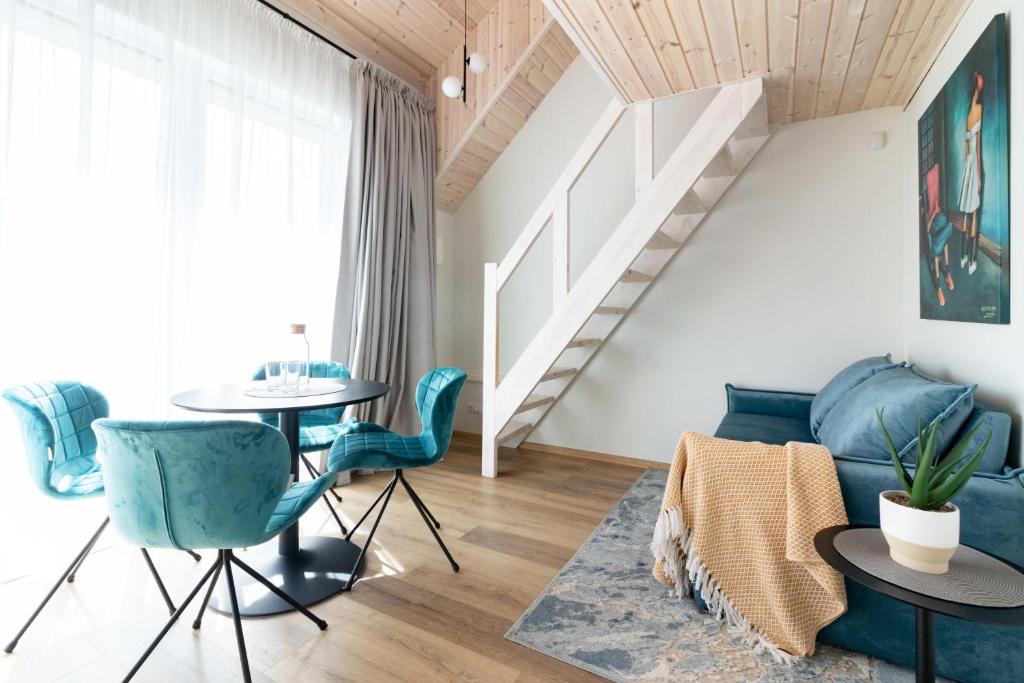 a living room with a blue couch and a table at VineWood Apartment, By Cohost in Palanga