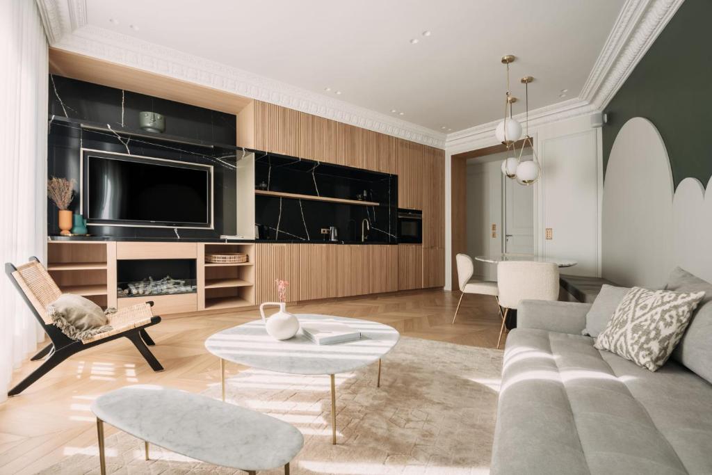 sala de estar con sofá y TV en HIGHSTAY - Luxury Serviced Apartments - Champs-Elysées en París