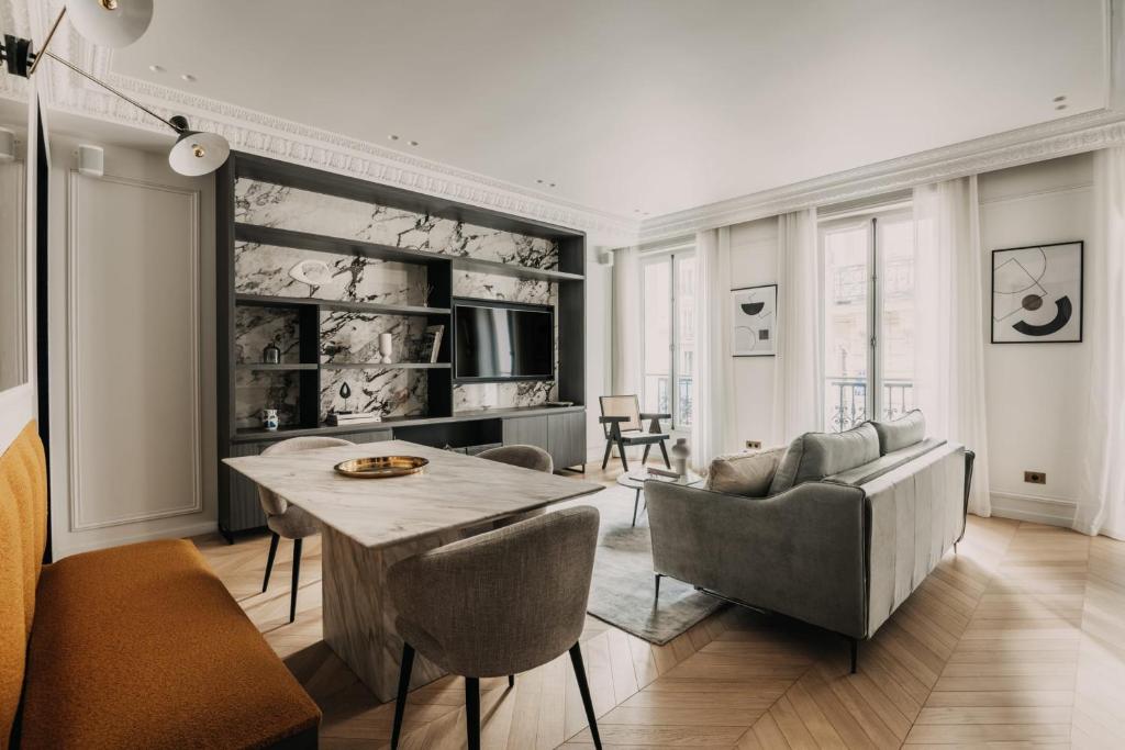 a living room with a table and chairs at HIGHSTAY - Luxury Serviced Apartments - Champs-Elysées in Paris