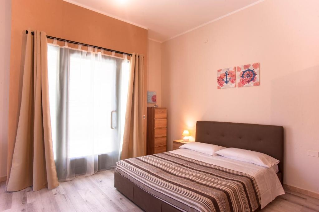 - une chambre avec un lit et une grande fenêtre dans l'établissement Loft Marini, à Villa San Pietro