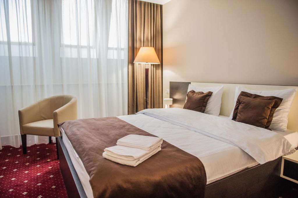 ein Hotelzimmer mit einem Bett mit Handtüchern darauf in der Unterkunft Bernardazzi Grand Hotel in Chişinău