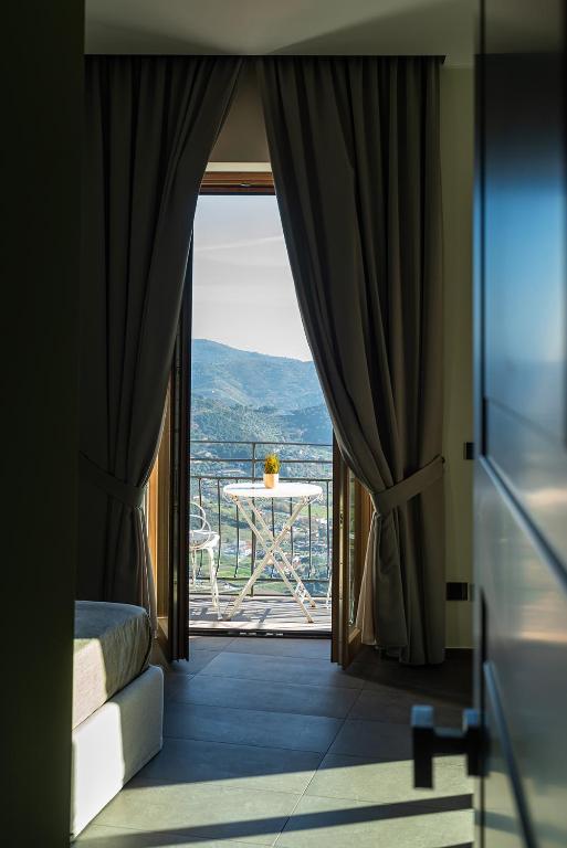 a bedroom with a view of a balcony with a table at De Gulia Charme and Relax in Castellabate
