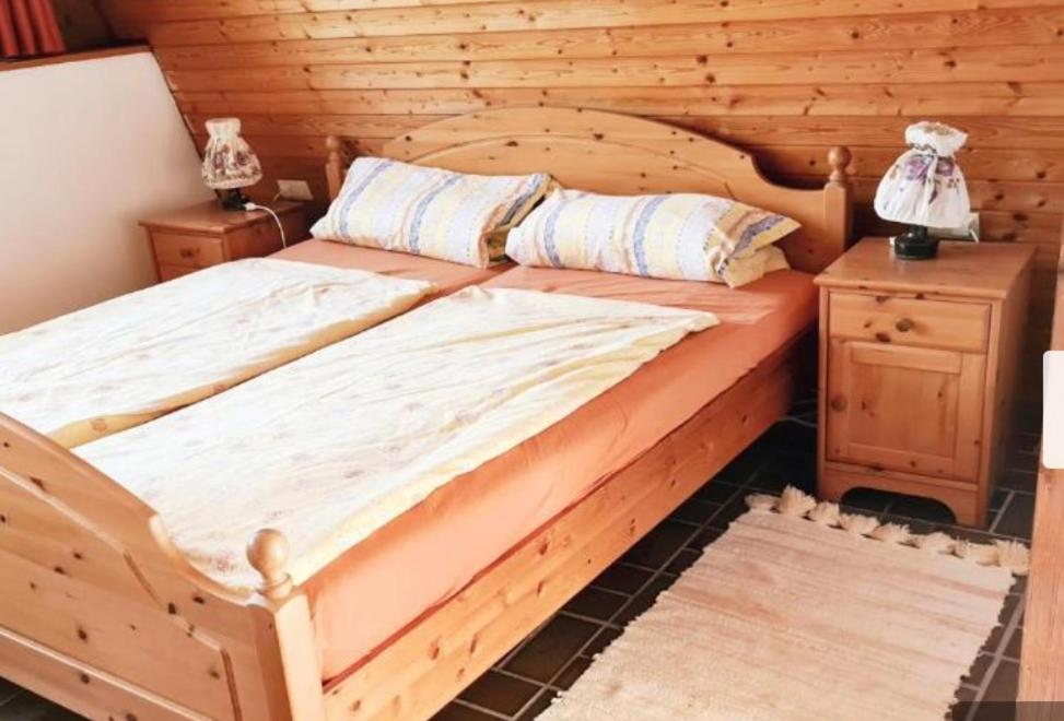 Cama de madera en habitación con pared de madera en Doppelzimmer Waldblick, en Sonnenbühl