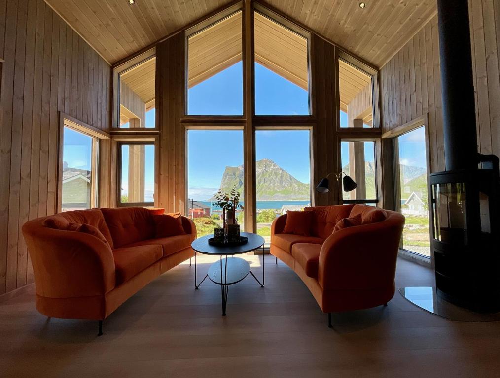 a living room with two orange couches and a table at Haukland Beach View - Superior cabin in Leknes