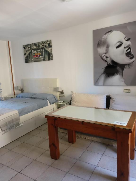 a room with two beds and a couch and a table at SERVILUx 2 in Torremolinos