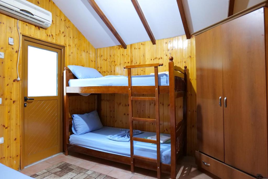 ein Etagenbett mit 2 Etagenbetten und einer Leiter in der Unterkunft GuestHouse Hamiti Llogara in Vlorë
