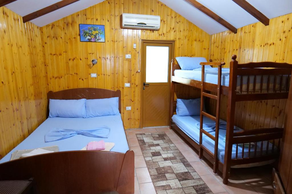 Zimmer mit 2 Etagenbetten und einem Stuhl in der Unterkunft GuestHouse Hamiti Llogara in Vlorë