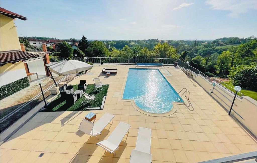 a swimming pool with white chairs at Amazing Home In Montegrosso Cinaglio in Monale