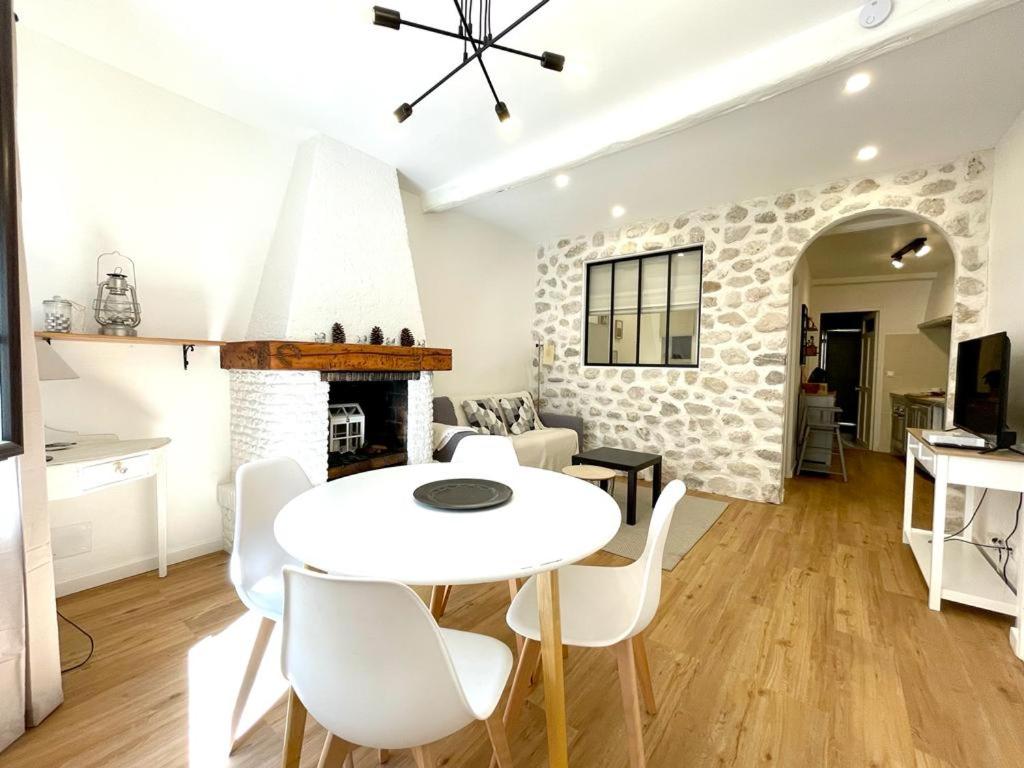 聖馬丹韋敘比耶的住宿－Cosy T2 Saint Martin Vésubie，客厅配有桌椅和壁炉