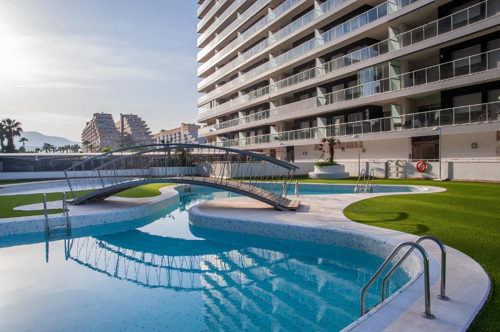 un puente sobre una piscina en un edificio en Holiday Deluxe Apartment Miramar Marina d'or, en Oropesa del Mar