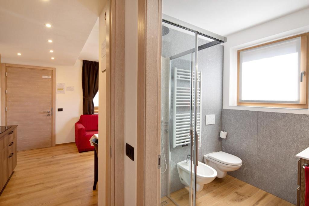 W łazience znajduje się toaleta i przeszklony prysznic. w obiekcie Appartamento Lago Casa Campacc w Livigno