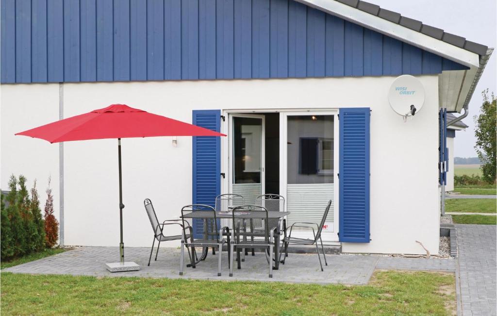 a table with chairs and an umbrella in front of a building at Ferienhaus 15 Altefhr in Altefähr