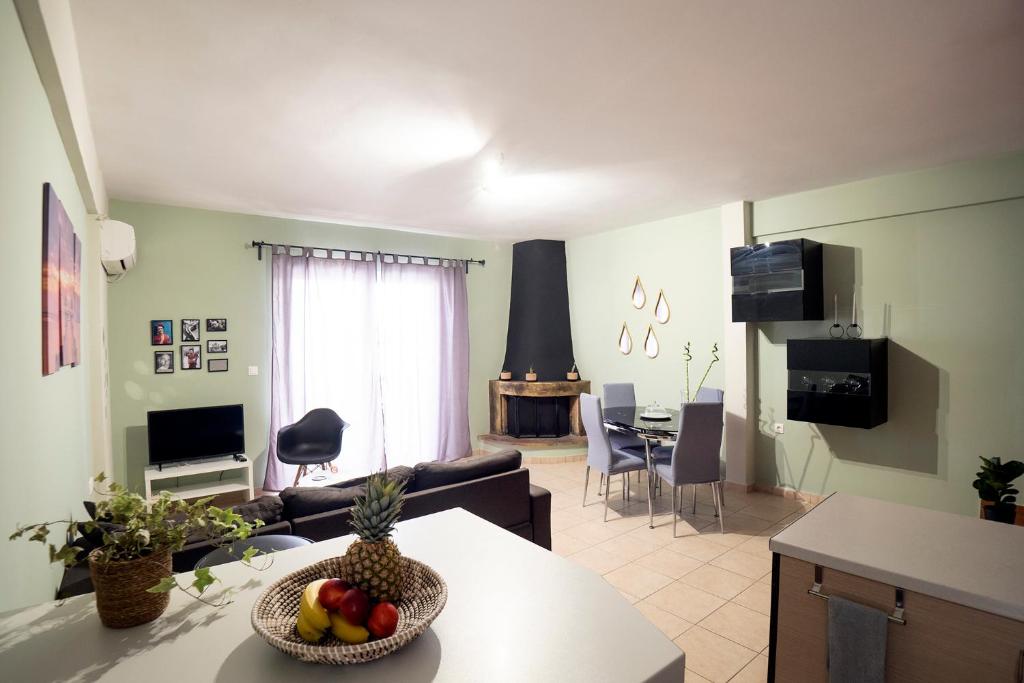 a living room with a couch and a table with a bowl of fruit at Cozy Apartment St John in Chalkida