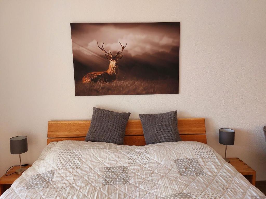 a painting of a deer on a wall above a bed at Ferienglück Unterkirnach in Unterkirnach