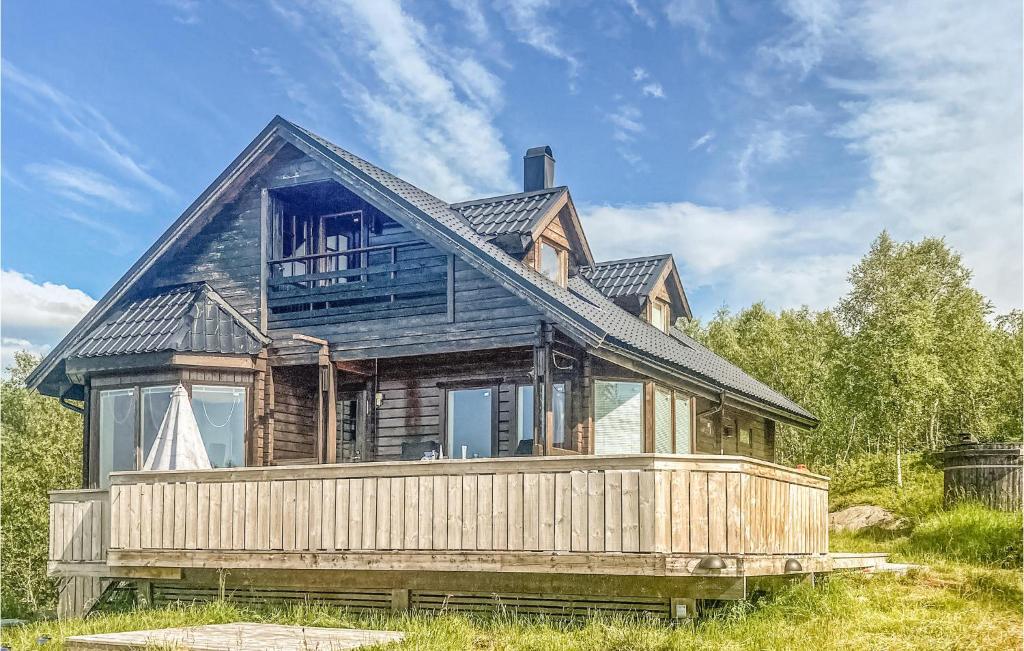 a house with a black roof on a wooden deck at Beautiful Home In Bogen I Ofoten With Jacuzzi, Sauna And 2 Bedrooms in Bogen