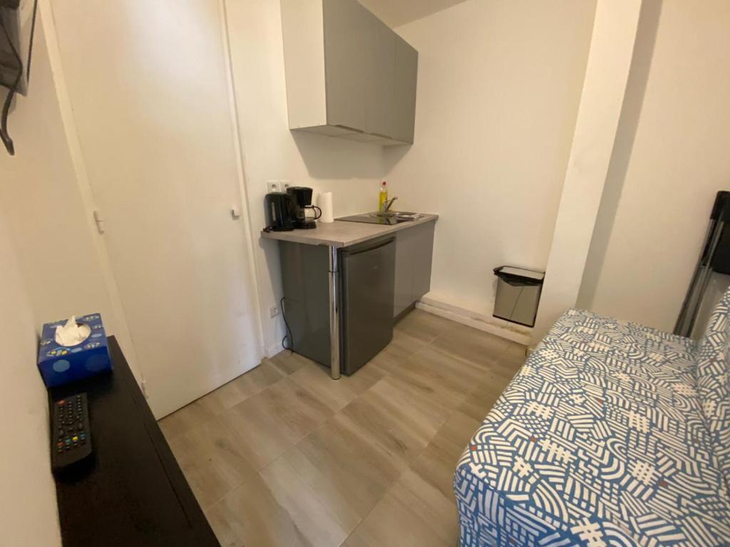 ein kleines Zimmer mit einer Küche und einem Sofa in der Unterkunft Mini studio 9m2 - 027 in Rouen