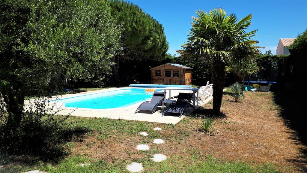 einen Pool mit Liegestühlen und ein Haus in der Unterkunft Gîte 3 étoiles 300m plage piscine privée grand jardin in Châtelaillon-Plage
