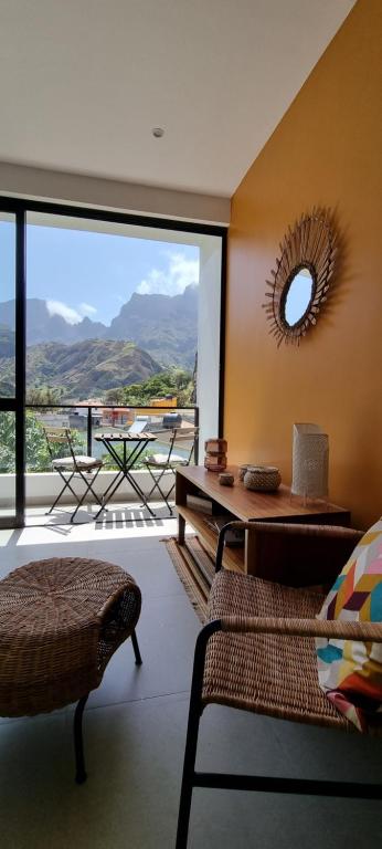 una sala de estar con una gran ventana con vistas a las montañas en Kasa d'Vizin en Paul