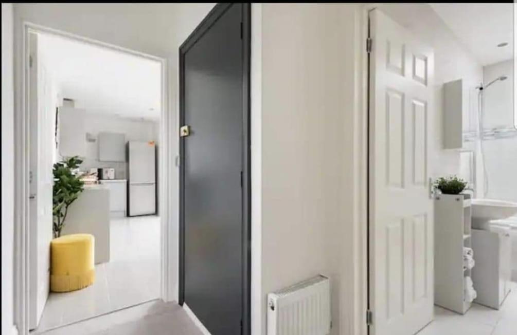 a bathroom with a black door and a sink and a mirror at Penthouse Luxury Apartment in Dagenham