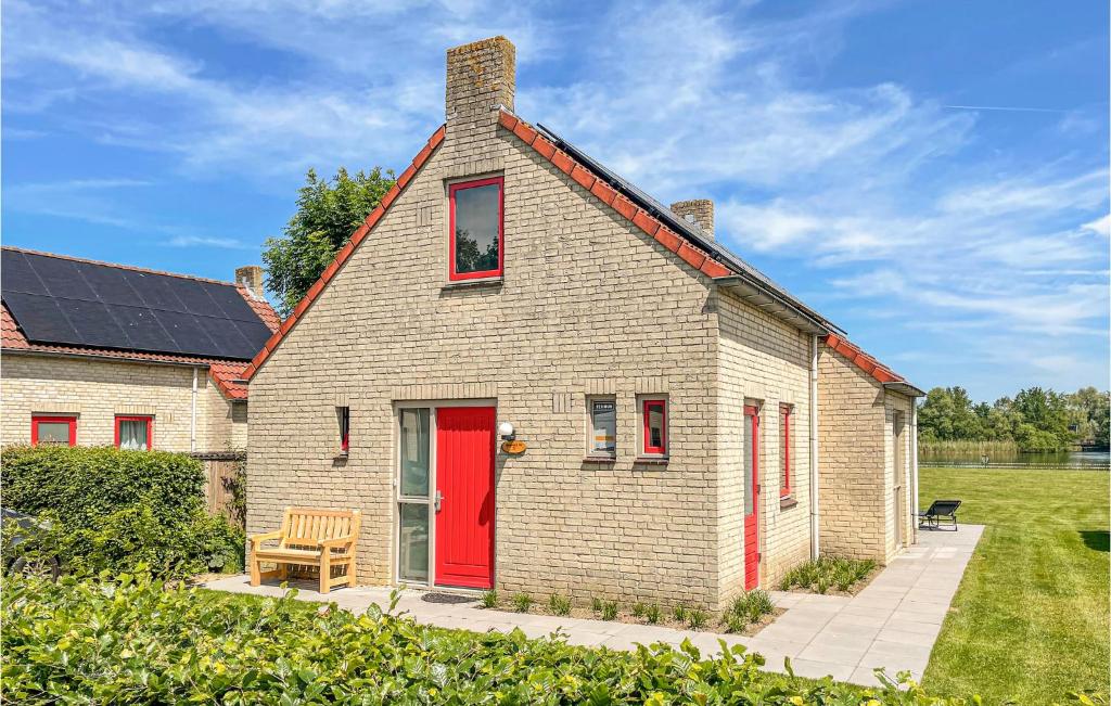 una pequeña casa de ladrillo con puerta roja en Awesome Home In Ewijk With House A Panoramic View en Ewijk
