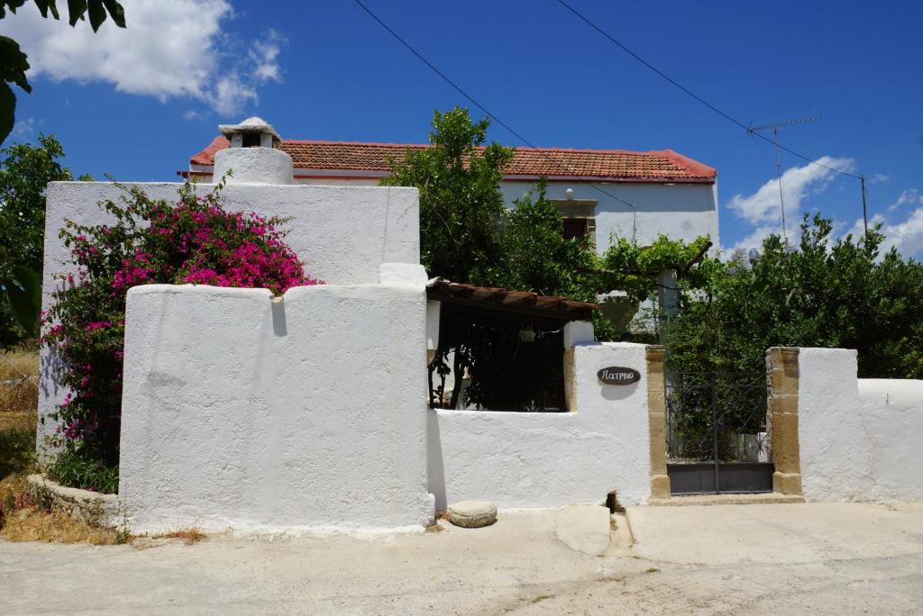 a person walking in front of a white house at Patriko Country House in Vóroi