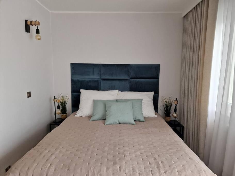 格地尼亞的住宿－Apartament Morski，卧室内的一张带蓝色床头板的大床