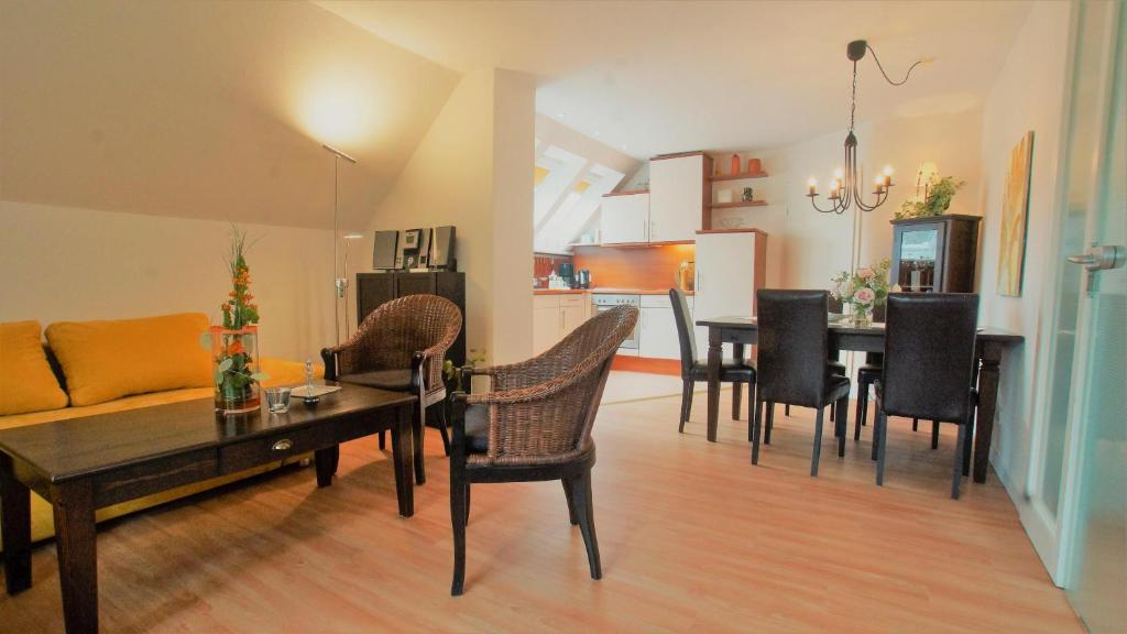 ein Wohnzimmer mit einem Sofa und einem Tisch mit Stühlen in der Unterkunft Haus Wexler 5 - OG in Cuxhaven