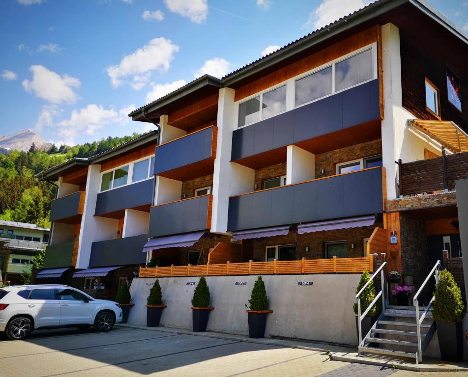 un bâtiment avec une voiture garée devant lui dans l'établissement Haus Wibmer, à Matrei in Osttirol