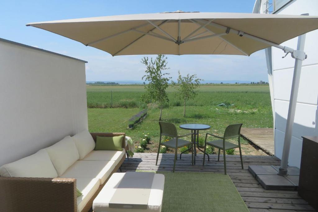 eine Terrasse mit einem Sofa, einem Tisch und einem Sonnenschirm in der Unterkunft Studio-Apartment in Trausdorf an der Wulka