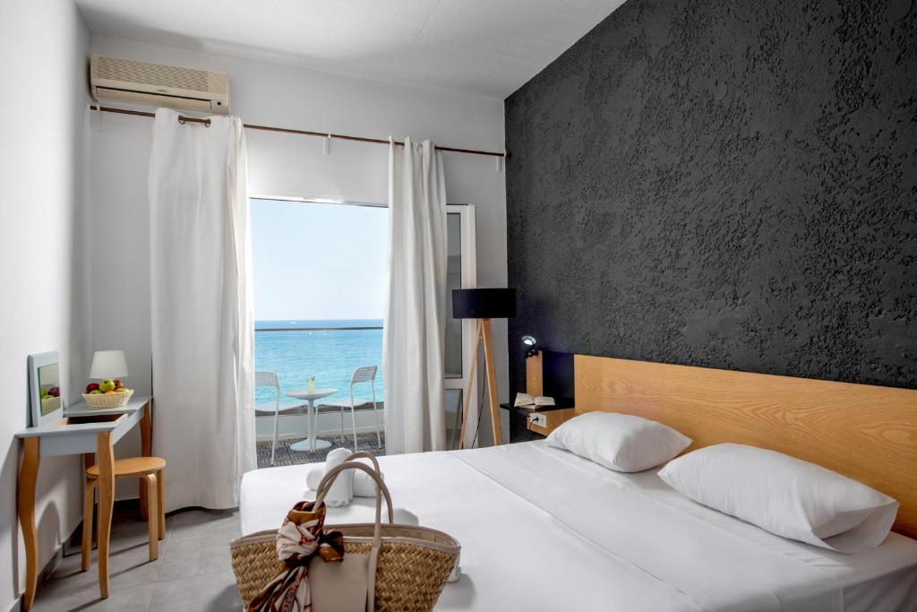 赫索尼索斯的住宿－Azure Mare Hotel，一间卧室设有一张床,享有海景