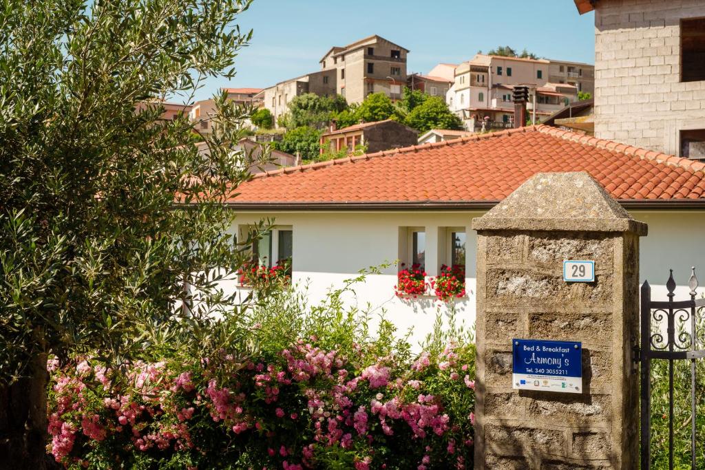 un pilar de piedra frente a una casa con flores en B&B Armony Bono, en Bono