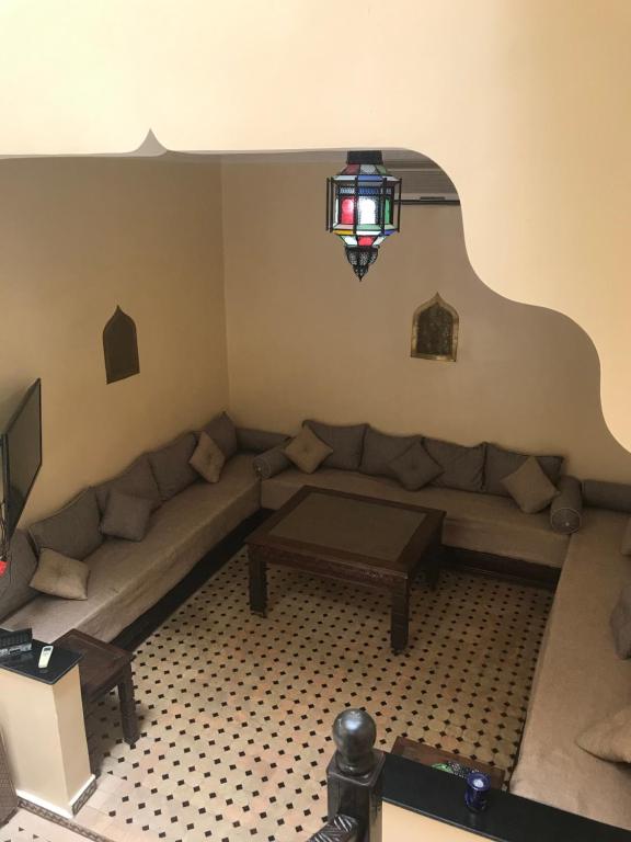 un soggiorno con un divano e un tavolo di Riad Syrine a Marrakech