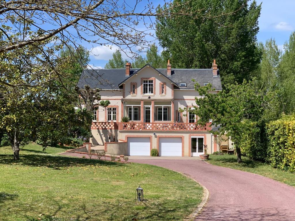 uma casa grande com uma entrada em frente em La Grenouillère - Chambre d'hôtes de charme em Ballan-Miré