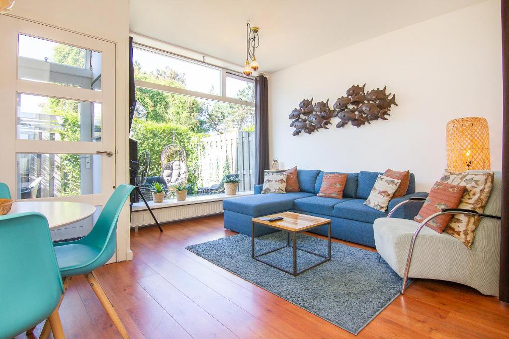 een woonkamer met een blauwe bank en een tafel bij Appartement De Zeemeermin, Free parking in Zandvoort