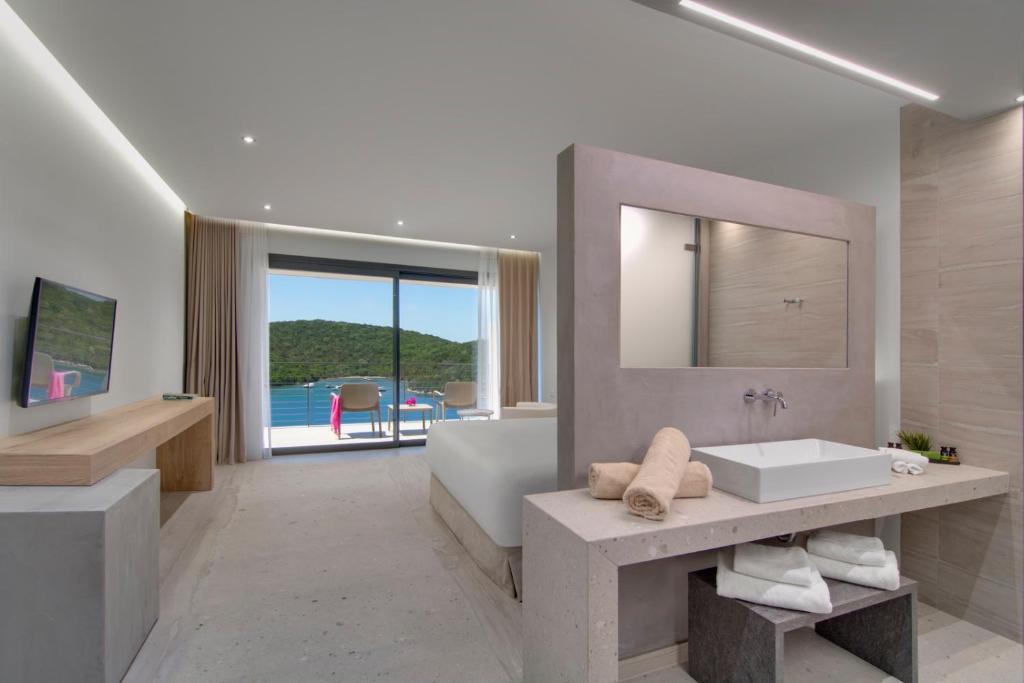 a bathroom with a tub and a sink and a mirror at Sivota Deamaris Luxury Boutique Hotel in Syvota