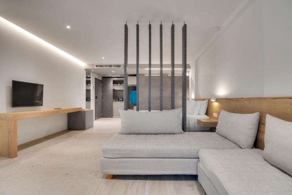 a living room with a couch and a tv at Sivota Deamaris Luxury Boutique Hotel in Syvota