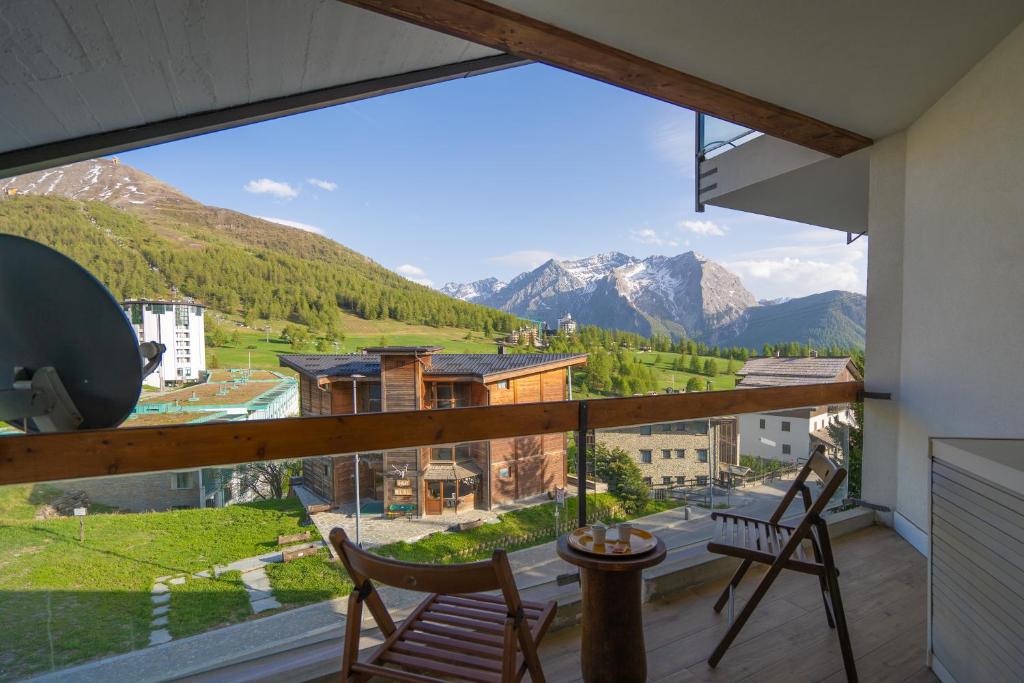 a balcony with chairs and a view of mountains at [SESTRIERE] Appartamento sulle piste in Sestriere