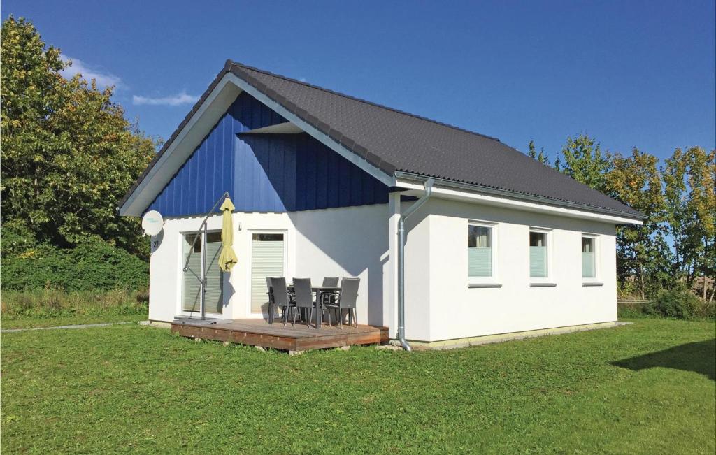 ein weißes und blaues Gebäude mit Stühlen auf einem Hof in der Unterkunft Ferienhaus 27 Altefhr in Altefähr
