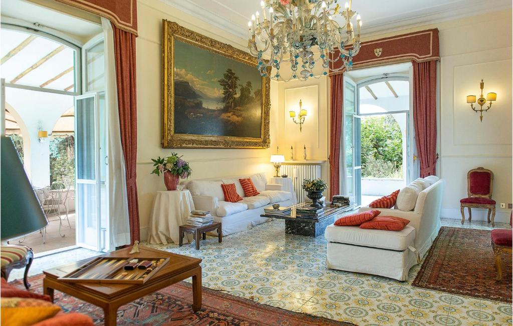 salon z białymi meblami i żyrandolem w obiekcie 5 Bedroom Amazing Home In Grottaferrata w mieście Grottaferrata