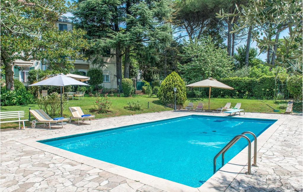 basen z leżakami i parasolami na dziedzińcu w obiekcie 5 Bedroom Amazing Home In Grottaferrata w mieście Grottaferrata
