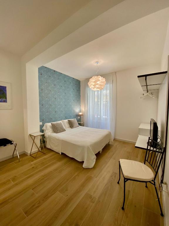 sypialnia z łóżkiem, krzesłem i telewizorem w obiekcie B&B Il Gabbiano w mieście Orbetello