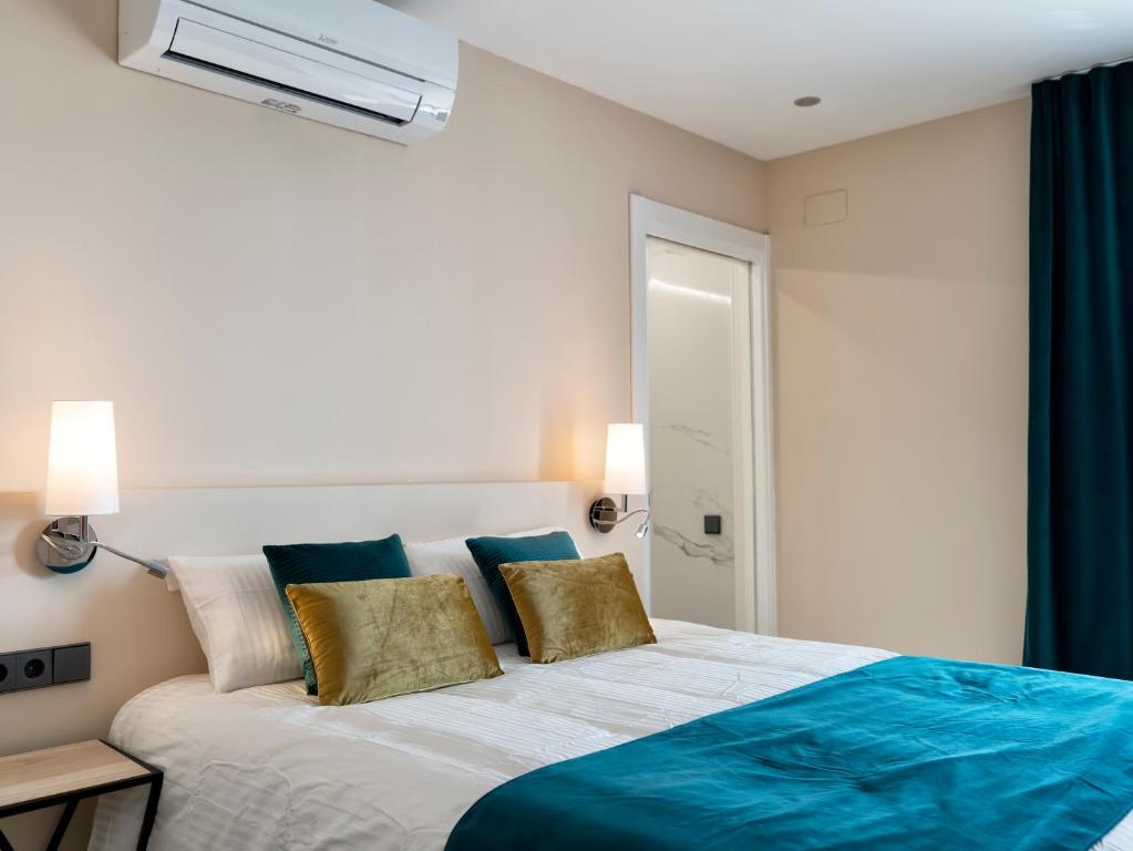 1 dormitorio con 1 cama con almohadas azules y doradas en Castellpetit en Castelldefels