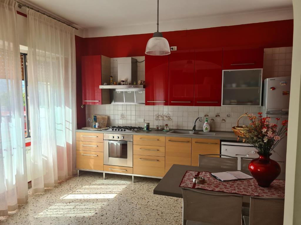 una cucina con armadi rossi e un piano cottura. di Casa Anna ad Agropoli