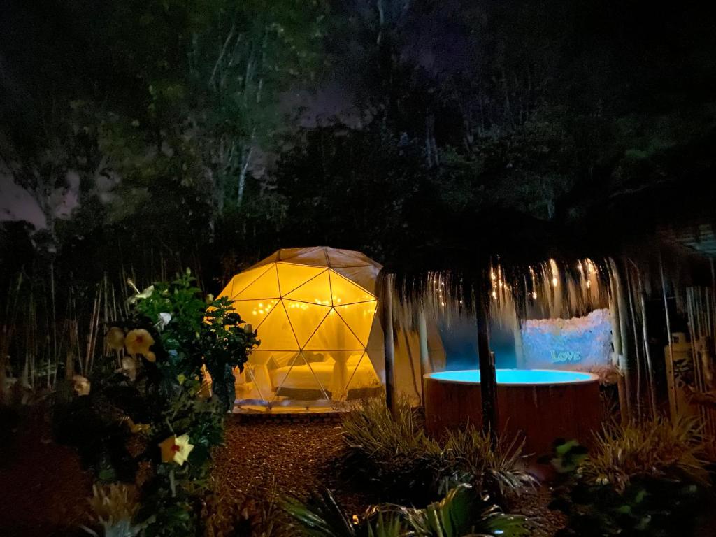 a lit up gazebo in a garden at night at IslaMontaña Glamping in Fómeque
