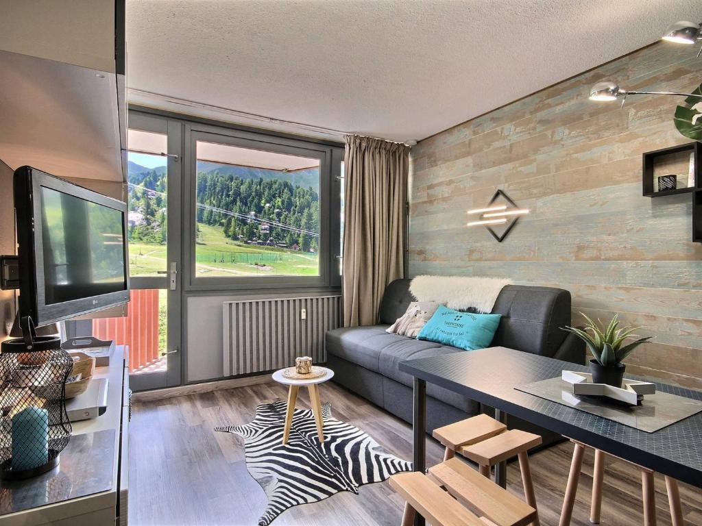 un salon avec un canapé et une télévision dans l'établissement Studio cabine rénové à Plagne Centre avec balcon et proche des pistes - FR-1-455-68, à La Plagne