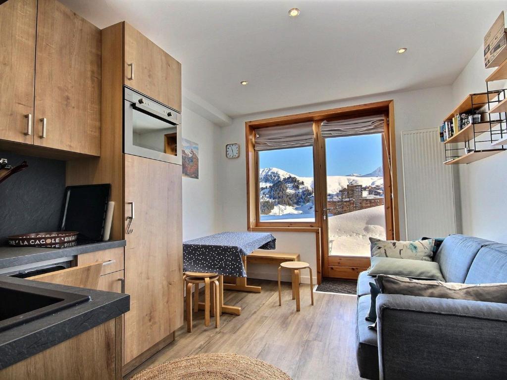 Il comprend une cuisine et un salon offrant une vue sur la montagne. dans l'établissement Bel Appartement Rénové 4/5 Pers. Pied des Pistes à La Plagne Centre - FR-1-455-66, à La Plagne