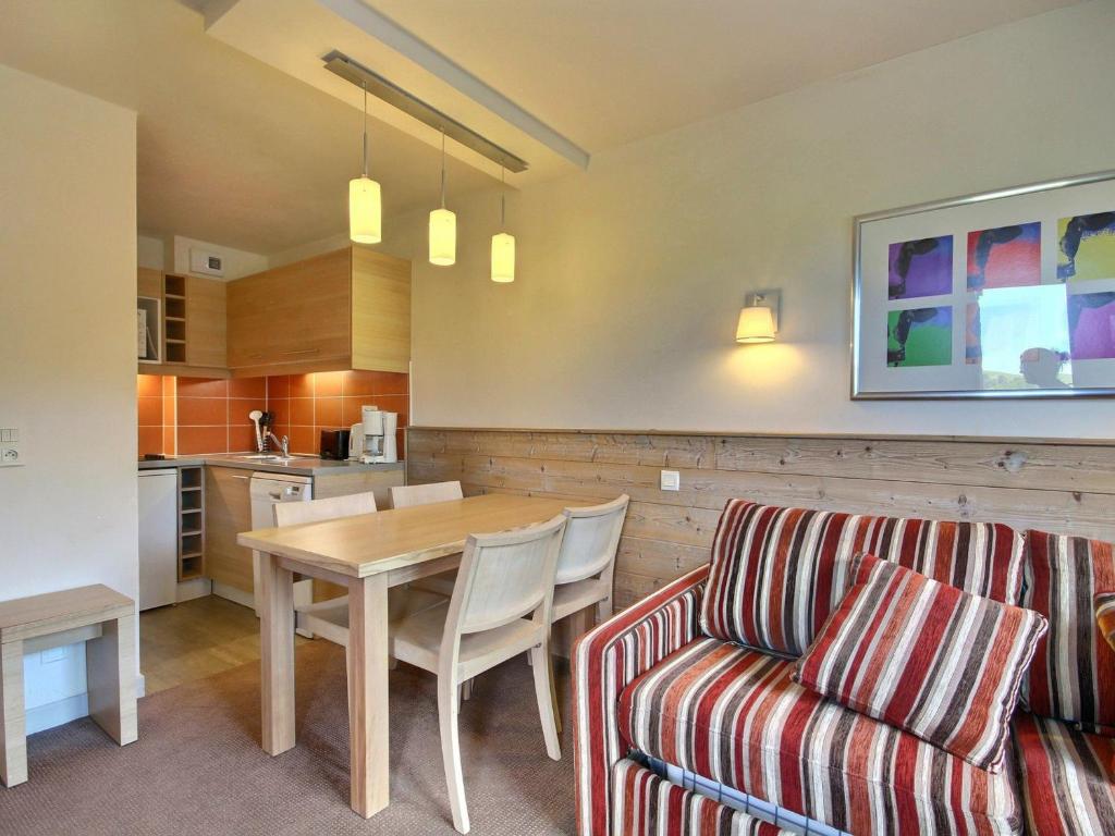 Il comprend un salon et une cuisine avec une table et un canapé. dans l'établissement Studio-cabine pour 4 avec balcon, proche pistes et commerces - FR-1-455-198, à La Plagne Tarentaise