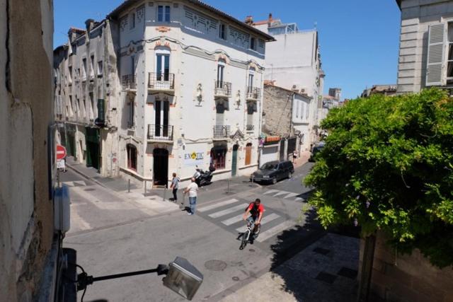 a person riding a bike down a city street at 2 pièces hyper centre de La Rochelle, proche du port et de la plage in La Rochelle