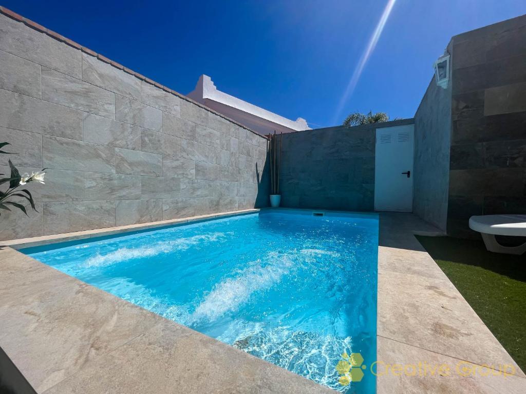 a swimming pool in the side of a house at Casa Nina in Vejer de la Frontera