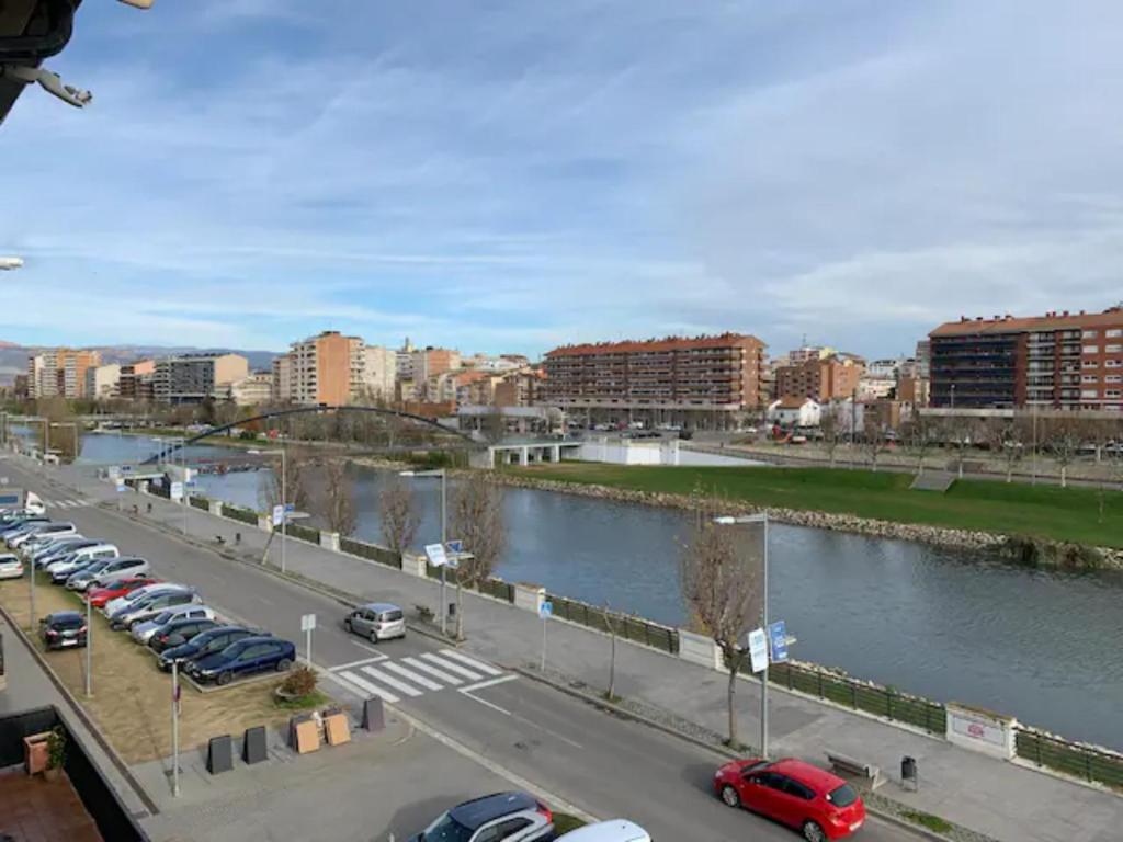 a parking lot with cars parked next to a river at Acojedor Duplex en Balaguer in Balaguer